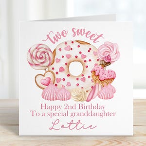 May include: A pink and white birthday card with a donut, candy, and other sweets. The card says "Two Sweet" and "Happy 2nd Birthday To a special granddaughter Lottie".