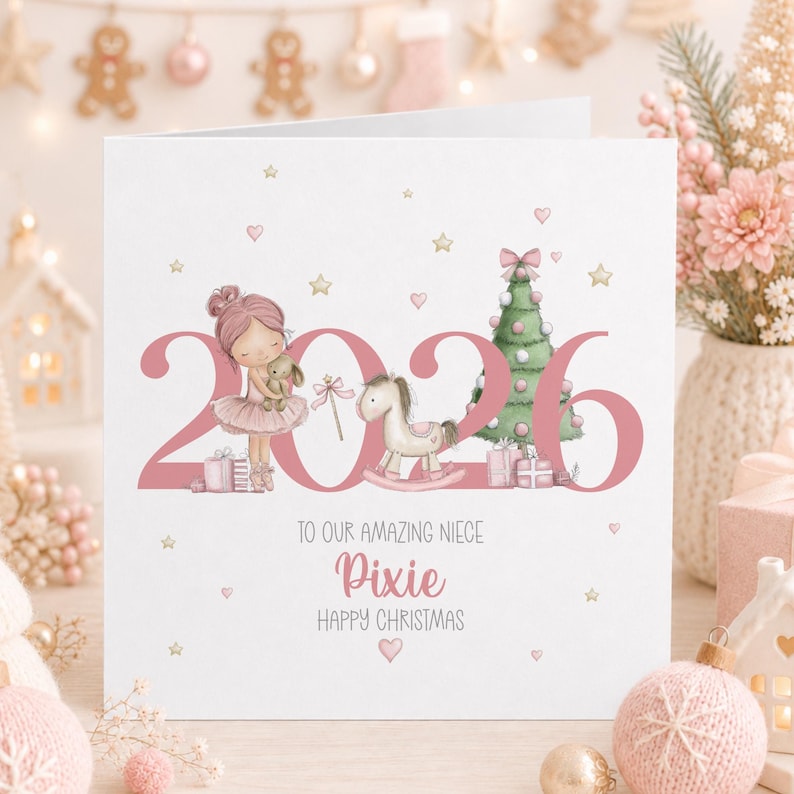 Personalised 2026 Christmas card for a great granddaughter, featuring a cute pink haired ballerina holding a bunny beside a pink Christmas tree, rocking horse and presents, with gold stars, pink hearts and the name Elsie.