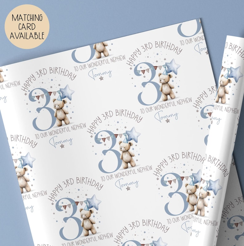 Luxury white personalised 3rd birthday wrapping paper, featuring a gorgeous teddy holding a blue star balloon standing next to a blue number 3 & matching bunting surrounded by little stars & the wording 'Happy 3rd Birthday to our wonderful Son/Grandson/Nephew, any relation' personalised with the child's name.