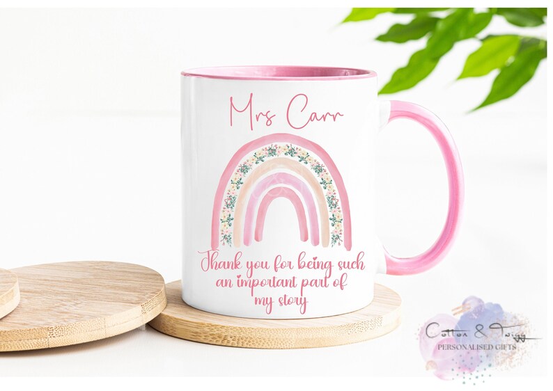May include: White ceramic mug with a pink rim and handle. The mug features a pink and peach rainbow with floral accents and the text "Mrs. Carr" and "Thank you for being such an important part of my story".