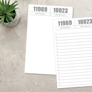 May include: A white notepad with two sections, each with a different zip code and city name. The top section says "11969 Southampton" and the bottom section says "10023 New York City". The notepad has a lined section for writing.