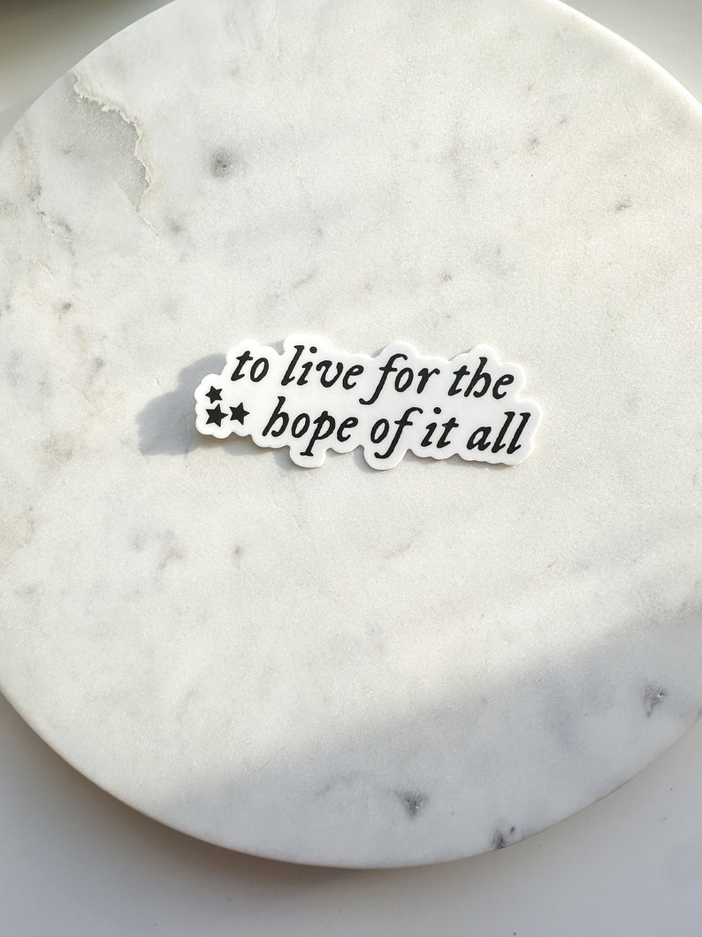 May include: White sticker with black text that reads "to live for the hope of it all".