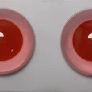 Peut inclure: Deux grands yeux globuleux ronds, rouges et roses. Les yeux sont en plastique et ont une finition brillante.