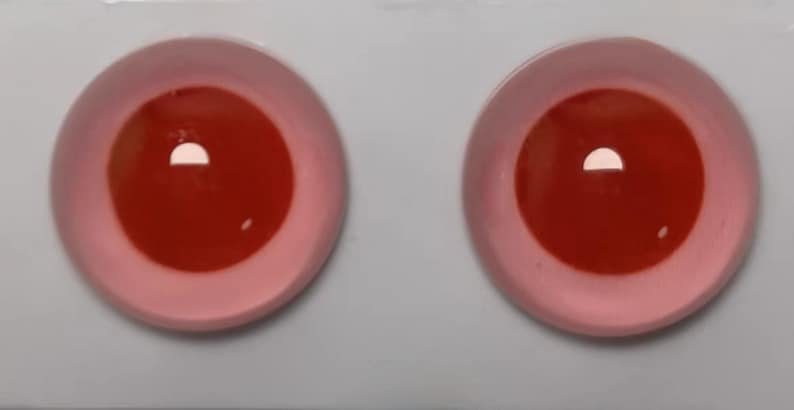 Peut inclure: Deux grands yeux globuleux ronds, rouges et roses. Les yeux sont en plastique et ont une finition brillante.