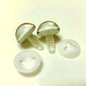 May include: Two clear, dome-shaped plastic toy eyes with screw-in posts and two white plastic washers. The eyes have a reflective surface and are designed for crafts and toy making.