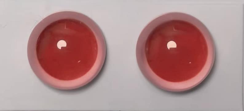 Peut inclure: Deux bols en c&eacute;ramique rose contenant un liquide rouge. Les bols sont sur une surface blanche.