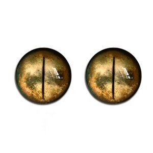 K&ouml;nnte beinhalten: Ein Paar realistisch aussehende Glasaugen in Gelb- und Braunt&ouml;nen. Die Augen haben eine vertikale schwarze Pupille.