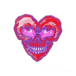 May include: Embroidered patch in the shape of a heart with a skull design. The patch features a red background with purple and pink accents. The skull has heart-shaped eyes and a grinning mouth with white teeth.