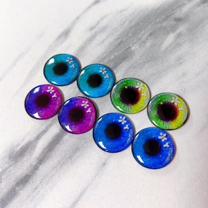 May include: Set of eight colorful glass eyes with white flower accents. The eyes are round and have black pupils. The colors include blue, green, purple, and pink.