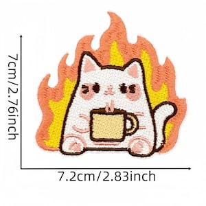 Op de afbeelding: Geborduurde patch met een witte kat die een koffiekopje vasthoudt, omringd door vlammen. De kat heeft roze wangen en is 7 cm hoog en 7,2 cm breed. De patch heeft een schattig, cartoonachtig ontwerp.
