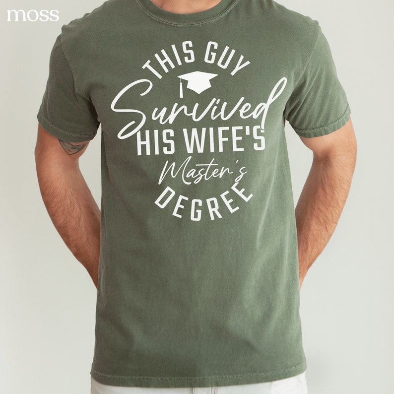 Peut inclure: Un t-shirt vert avec du texte blanc qui dit "This Guy Survived His Wife's Master's Degree".