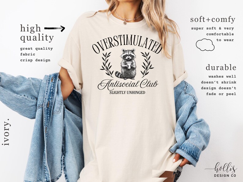 Puede incluir: Camiseta color marfil con el texto "OVERSTIMULATED Antisocial Club SLIGHTLY UNHINGED" y un gr&aacute;fico de mapache. La camiseta est&aacute; hecha de una tela suave y c&oacute;moda y tiene un dise&ntilde;o n&iacute;tido.