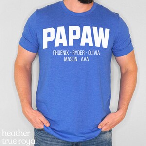 May include: A royal blue t-shirt with the word "PapaW" in white text. Below the word "PapaW" is the text "Phoenix - Ryder - Olivia Mason - Ava" in white text.