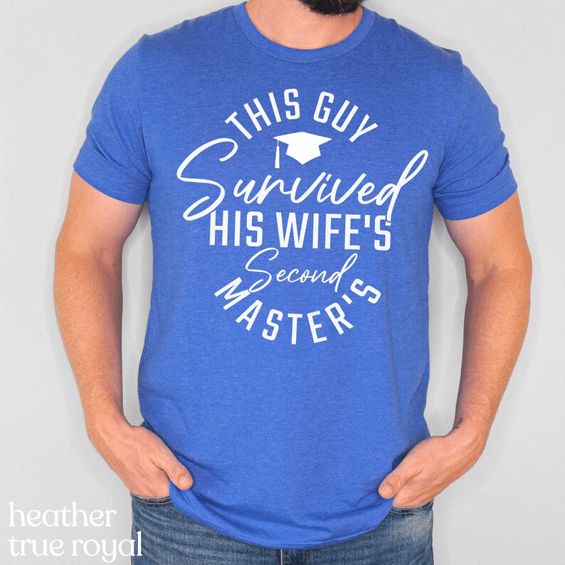 May include: A blue t-shirt with white text that reads "This Guy Survived His Wife's Second Master's". The text is in a circle with a graduation cap at the top.