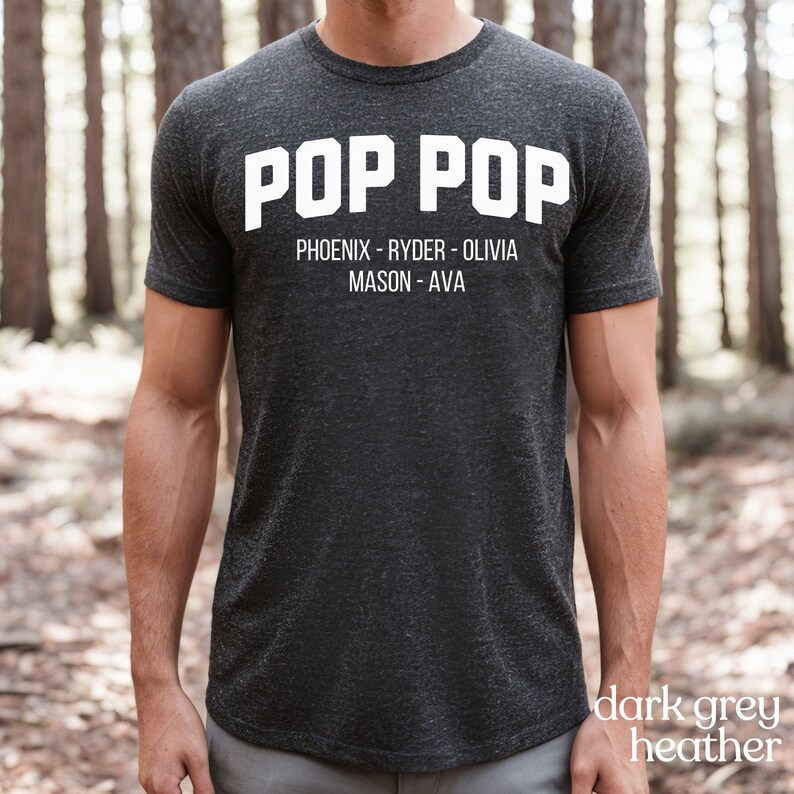 May include: Dark grey heather t-shirt with the text "POP POP" in white. Below the text are the names "PHOENIX - RYDER - OLIVIA MASON - AVA" in white.