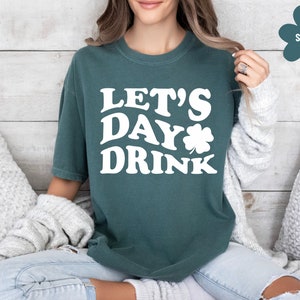 May include: A teal green t-shirt with the text "Let's Day Drink" in white with a shamrock graphic.