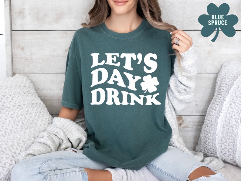 May include: A teal green t-shirt with the text "Let's Day Drink" in white with a shamrock graphic.