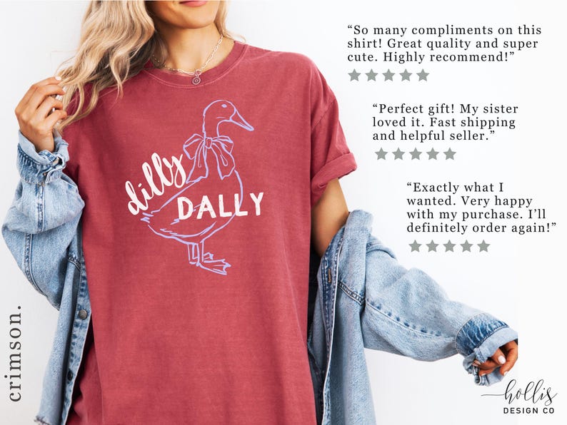 May include: Crimson t-shirt with a duck graphic and the words "dilly dally". The duck has a bow. The shirt is from Hollis Design Co. The image also includes customer reviews.