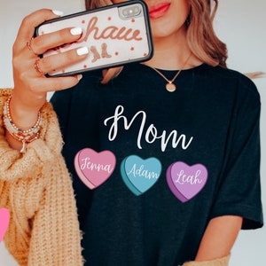 May include: Black t-shirt with the word "Mom" and three candy hearts with the names "Jenna", "Adam", and "Leah" printed on them.