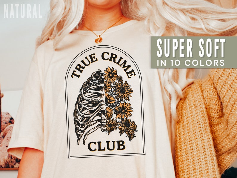 May include: A white t-shirt with a graphic of a ribcage and flowers. The text "TRUE CRIME CLUB" is printed on the shirt. The shirt is super soft and available in 10 colors.
