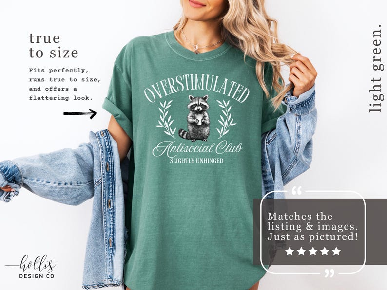 Puede incluir: Camiseta verde claro con el texto "OVERSTIMULATED Antisocial Club SLIGHTLY UNHINGED" y un gr&aacute;fico de mapache. La camiseta es de corte holgado y tiene las mangas enrolladas. Tambi&eacute;n es visible el texto "true to size".