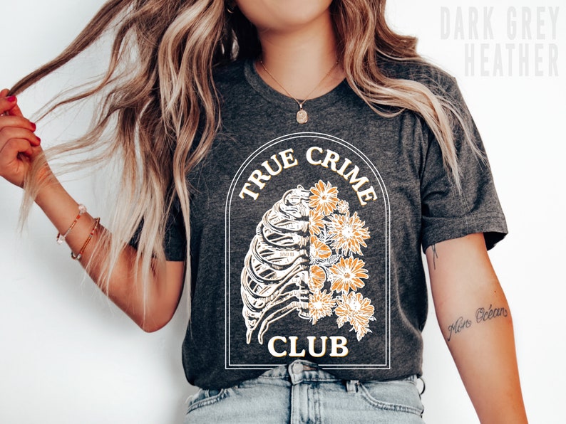 May include: A dark grey heather t-shirt with a graphic of a ribcage with flowers and the text "True Crime Club".