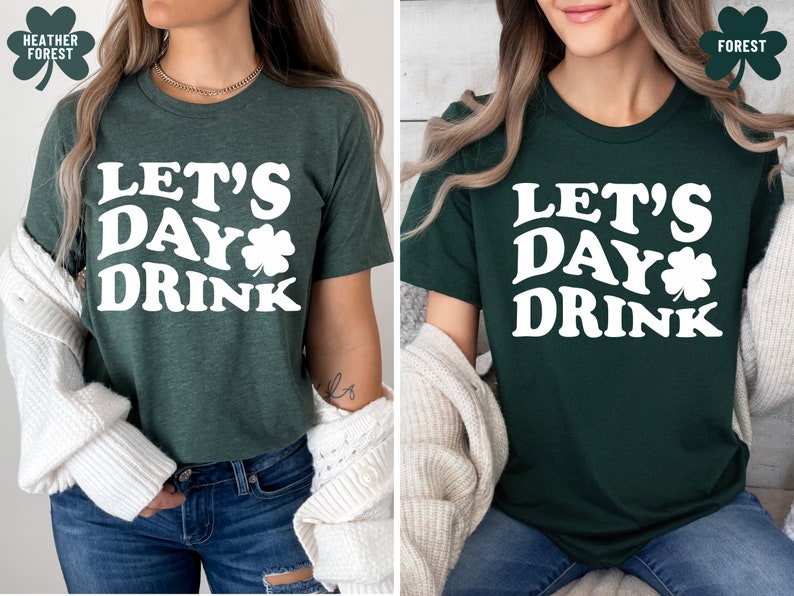 May include: A green t-shirt with white text that says "Let's Day Drink" and a shamrock graphic. The shirt is shown on a model wearing blue jeans and a white cardigan.