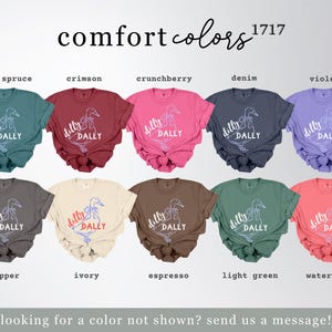 May include: A selection of Comfort Colors t-shirts in shades like blue spruce, crimson, and violet. Each tee displays a duck graphic with the words "dilly dally". The text "comfort colors" and "1717" are at the top.