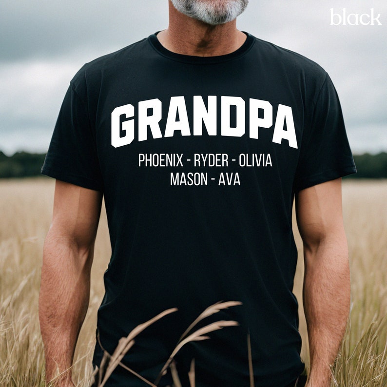 May include: Black t-shirt with white text that reads "GRANDPA" and "PHOENIX - RYDER - OLIVIA MASON - AVA"