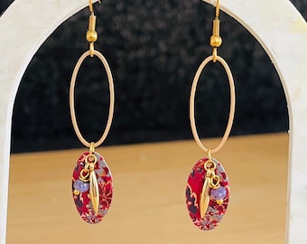 Pendientes colgantes dorados y estampado de flores moradas