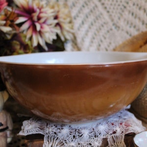 Puede incluir: Un tazón de mezclar marrón y blanco con un interior blanco y un exterior marrón. El tazón está sentado sobre una servilleta blanca.