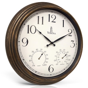 May include: A round wall clock with a dark bronze-colored frame and an off-white face. The clock features black Arabic numerals, black hands, and the word Verona with a tower icon. Two smaller circular gauges display humidity and temperature.