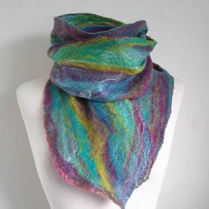 May include: A vibrant, hand-felted scarf in teal, purple, green, and yellow hues. The scarf is displayed on a white mannequin, highlighting its textured, artistic design. The scarf's unique colour palette and soft texture make it a distinctive accessory.