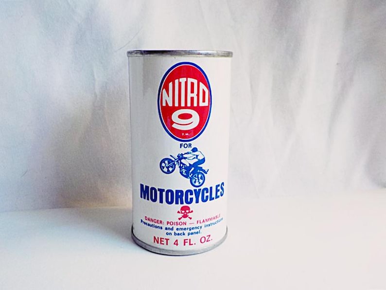 Puede incluir: Una lata blanca con una etiqueta roja y azul. La etiqueta dice "NITRD 9" en un c&iacute;rculo rojo con un n&uacute;mero 9 blanco. La etiqueta tambi&eacute;n dice "FOR MOTORCYCLES" en letras azules. La lata tiene un s&iacute;mbolo de calavera y huesos cruzados y el texto "DANGER: POISON - FLAMMABLE" en la etiqueta. La lata dice "NET 4 FL. OZ."