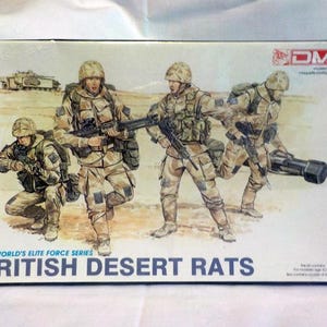 Może przedstawiać: Pudełko z zestawem modeli do sklejania w skali 1:35 brytyjskich żołnierzy Desert Rats. Grafika na pudełku przedstawia czterech żołnierzy w pustynnym kamuflażu, którzy niosą broń i wyposażenie. Tekst na pudełku brzmi "1:35 World's Elite Force Series British Desert Rats".