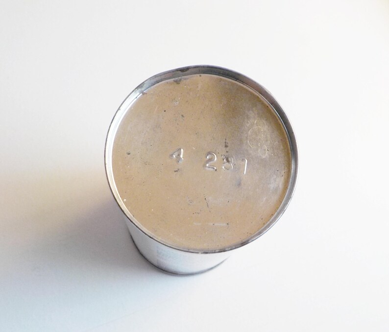 Puede incluir: La parte inferior de un recipiente de metal plateado con el n&uacute;mero "4231" impreso en la parte inferior.