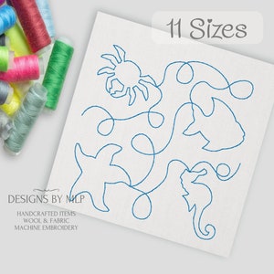 May include: A white fabric square featuring blue embroidered sea creatures: a crab, fish, starfish, and seahorse. The text "11 Sizes" is above the design. Spools of colorful thread are in the background. The text "DESIGNS BY MLP" is at the bottom.