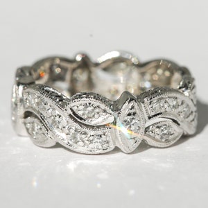 Pu&ograve; includere: Un anello a fascia d'argento con un delicato design di foglie e diamanti.