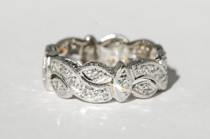 Pu&ograve; includere: Un anello a fascia d'argento con un delicato design di foglie e diamanti.