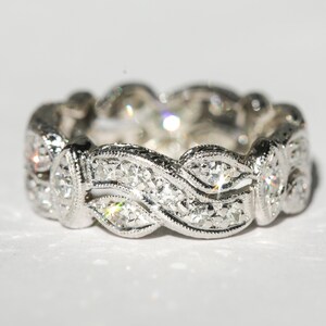 Pu&ograve; includere: Un anello a fascia d'argento con un design a onde incastonato con piccoli diamanti.