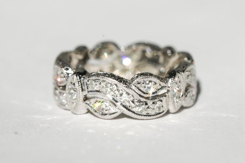 Pu&ograve; includere: Un anello a fascia d'argento con un design a onde incastonato con piccoli diamanti.