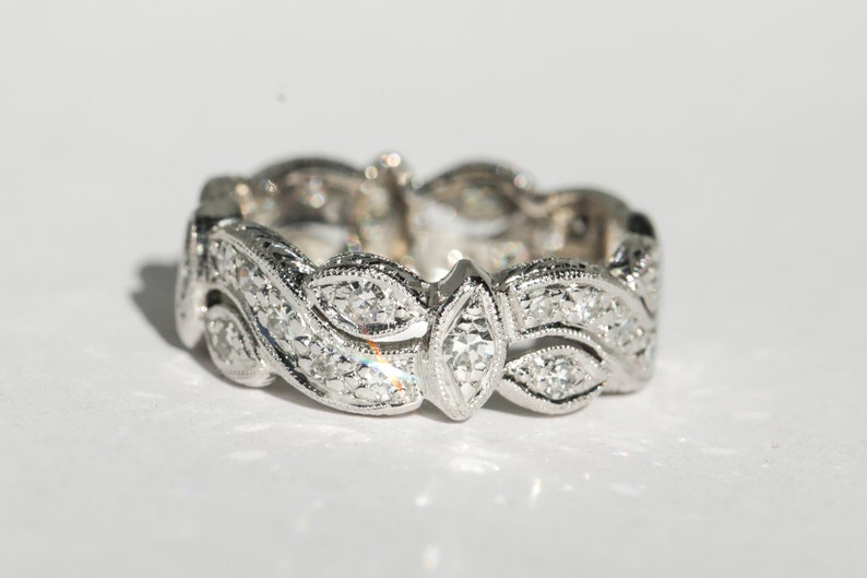 Pu&ograve; includere: Un anello a fascia d'argento con un delicato design di foglie e diamanti.