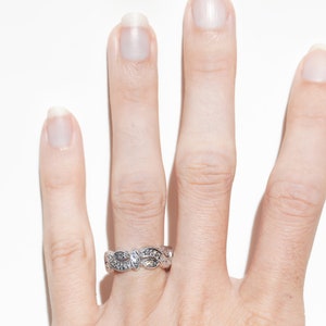 Pu&ograve; includere: Un anello d'argento con un delicato design di foglie e piccoli diamanti.