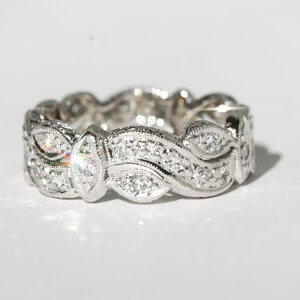 Pu&ograve; includere: Un anello a fascia d'argento con un delicato design a onde incastonato con piccoli diamanti.