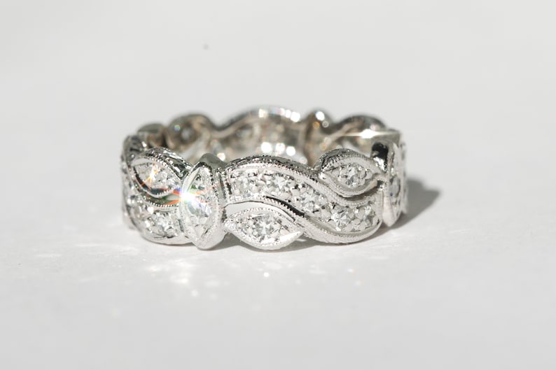 Pu&ograve; includere: Un anello a fascia d'argento con un delicato design a onde incastonato con piccoli diamanti.