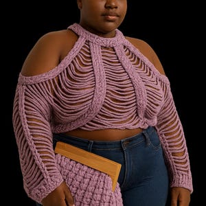 May include: A mauve-colored, open-weave crochet top with long sleeves and a halter neckline. The top is paired with blue jeans and a matching crochet clutch with a wooden frame. The background is black.