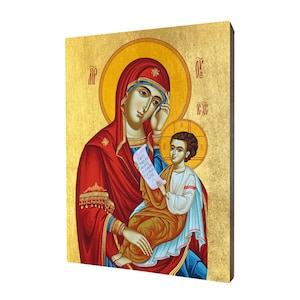 May include: A religious icon depicting the Virgin Mary holding a young Jesus. Mary is wearing a red robe with gold trim and a blue cloak. Jesus is wearing a white robe with a red sash. The icon is painted on a wooden panel with a gold background.
