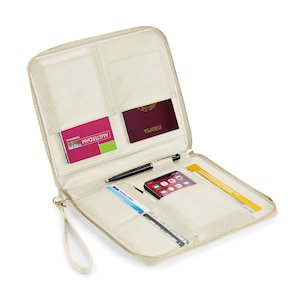 May include: A cream-colored travel wallet with a zipper closure and a wrist strap. The wallet is open and has multiple pockets and slots for holding items like a passport, phone, cards, and a pen.