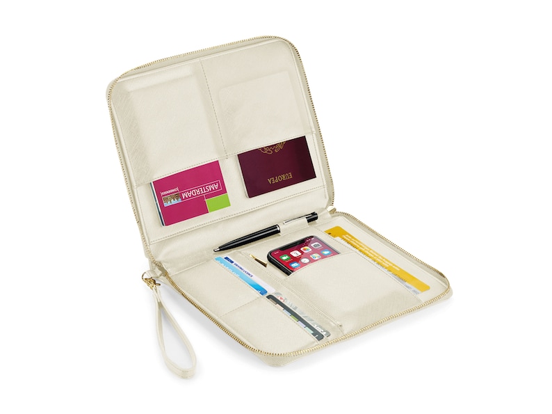 May include: A cream-colored travel wallet with a zipper closure and a wrist strap. The wallet is open and has multiple pockets and slots for holding items like a passport, phone, cards, and a pen.