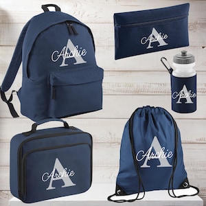 May include: A navy blue school set including a backpack, pencil case, water bottle, lunch bag, and drawstring bag. Each item is printed with the name "Archie" and a large white "A". Ideal for school or travel.